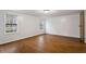 An airy bedroom with wood-look flooring, bright windows, and a neutral color palette offers a peaceful and inviting space at 1705 Old Nc 10 Hwy, Hillsborough, NC 27278
