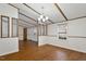 Open living room with hardwood floors, a chandelier, and large windows providing natural light at 1705 Old Nc 10 Hwy, Hillsborough, NC 27278