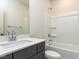 Well-lit bathroom with a single sink vanity and a shower-tub combo with built-in shelving at 1804 Bright Lantern Way, Wendell, NC 27591