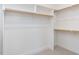Large walk-in closet with carpet and built-in white shelving and gold hardware at 1804 Bright Lantern Way, Wendell, NC 27591