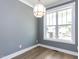 Bright dining room with modern light fixture, large window, and wood floors at 1804 Bright Lantern Way, Wendell, NC 27591
