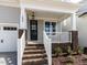 Charming front porch with brick accents and a classic black front door, creating a welcoming entryway to the home at 1804 Bright Lantern Way, Wendell, NC 27591