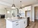 Open kitchen featuring a granite island, modern lighting, and stainless steel dishwasher at 1804 Bright Lantern Way, Wendell, NC 27591