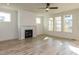 Bright and airy living room featuring a modern fireplace, large windows, and light wood floors at 1804 Bright Lantern Way, Wendell, NC 27591