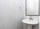 Elegant powder room with pedestal sink, modern mirror, and minimalist design at 1804 Bright Lantern Way, Wendell, NC 27591