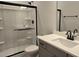 Bathroom with shower featuring glass doors and modern vanity with dark hardware at 55 New Liberty Dr, Youngsville, NC 27596