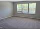 Bedroom with carpet flooring and natural light through a bank of windows at 55 New Liberty Dr, Youngsville, NC 27596