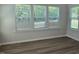 Bright bedroom showcasing wood-look floors, recessed lighting, and large windows providing ample natural light at 55 New Liberty Dr, Youngsville, NC 27596