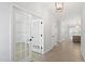 Bright hallway featuring hardwood floors, white trim, and French doors leading to a room at 55 New Liberty Dr, Youngsville, NC 27596