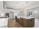 Bright kitchen with white cabinets, stainless appliances, hardwood floors, a large island with seating, and pendant lighting at 55 New Liberty Dr, Youngsville, NC 27596