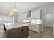 Modern kitchen featuring white cabinets, stainless steel appliances, a large island, and designer lighting at 55 New Liberty Dr, Youngsville, NC 27596