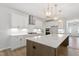 Bright and modern kitchen featuring white cabinets, quartz countertops, stainless steel appliances, and a large island at 55 New Liberty Dr, Youngsville, NC 27596