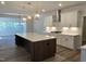 Modern kitchen with white cabinets, large island with sink, stainless steel vent hood, and open concept design at 55 New Liberty Dr, Youngsville, NC 27596