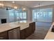 Open kitchen featuring island with farm sink, wood flooring, pendant lighting, and seamless flow to the living area at 55 New Liberty Dr, Youngsville, NC 27596