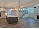 Open-concept kitchen featuring an island with farm sink and a view of the living room with fireplace and staircase at 55 New Liberty Dr, Youngsville, NC 27596