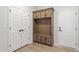 Mudroom features light wood floors, built-in bench, hall tree, and storage cabinets at 55 New Liberty Dr, Youngsville, NC 27596