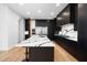Modern kitchen with large island, black cabinetry, and stainless steel appliances at 6701 Green Hollow Ct, Wake Forest, NC 27587