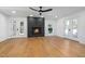 Open living room with hardwood floors, fireplace, modern fan, and French doors at 6701 Green Hollow Ct, Wake Forest, NC 27587
