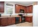 Modern kitchen featuring dark wood cabinets, black appliances, and ample counter space at 6817 Osprey Landing Dr, Wendell, NC 27591