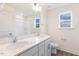 Bathroom featuring a double vanity, bright white walls, and a shower/tub combo bathed in natural light at 85 Kissington Way, Benson, NC 27504