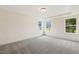 Bright bedroom features neutral walls, plush gray carpet, and abundant natural light from three large windows at 85 Kissington Way, Benson, NC 27504
