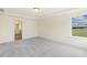 Spacious bedroom with ensuite bathroom features neutral walls, gray carpet, and natural light from large windows at 85 Kissington Way, Benson, NC 27504