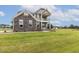 Attractive two-story home with gray siding, stone accents, and a welcoming double stacked front porch at 85 Kissington Way, Benson, NC 27504