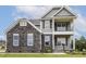 Attractive two-story home with gray siding, stone accents, and a welcoming double stacked front porch at 85 Kissington Way, Benson, NC 27504