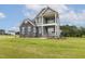 Attractive two-story home with gray siding, stone accents, and a welcoming double stacked front porch at 85 Kissington Way, Benson, NC 27504