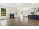 Open-concept living room with fireplace, hardwood floors, and view to kitchen with island at 85 Kissington Way, Benson, NC 27504