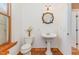 Charming bathroom with pedestal sink and terracotta tile floor at 105 Kingfisher Way, Louisburg, NC 27549