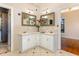 Double vanity bathroom with large mirrors and light beige tile at 105 Kingfisher Way, Louisburg, NC 27549