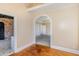 Bright hallway with hardwood floors and arched doorway leading to bedrooms at 105 Kingfisher Way, Louisburg, NC 27549