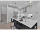 Bright kitchen with white cabinetry, a stainless steel refrigerator, and an island with counter seating at 1105 Glascock St # 102, Raleigh, NC 27610