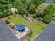 Aerial view of a landscaped backyard featuring a deck with seating, green grass, and mature trees at 127 Fairfield Cir, Dunn, NC 28334