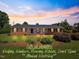 Charming brick home featuring a manicured lawn and covered front porch, perfect for enjoying the sunset at 127 Fairfield Cir, Dunn, NC 28334