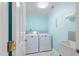 Functional laundry room with a washer, dryer, utility sink, and bright blue walls at 127 Fairfield Cir, Dunn, NC 28334
