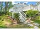 Elevated deck with stairs surrounded by lush greenery and a charming stone pathway at 1408 Ferrell Ct, Creedmoor, NC 27522
