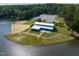 Aerial view of waterfront building with a sandy beach area, boat docks, and parking at 145 Ottawa Dr, Louisburg, NC 27549