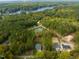 Aerial view of homes nestled in a lush forest, with a glimpse of the lake nearby at 145 Ottawa Dr, Louisburg, NC 27549