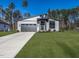 Modern home featuring sleek gray siding, a gray garage door, and well-manicured lawn at 145 Ottawa Dr, Louisburg, NC 27549