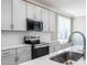 Modern kitchen featuring stainless steel appliances, gray cabinets, tiled backsplash, and sink at 145 Ottawa Dr, Louisburg, NC 27549
