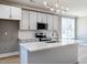 Bright kitchen features stainless steel appliances, gray cabinets, tiled backsplash, and laminate floors at 145 Ottawa Dr, Louisburg, NC 27549