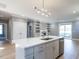 Kitchen island with stainless steel dishwasher and sink; gray cabinetry, laminate flooring, with living space at 145 Ottawa Dr, Louisburg, NC 27549