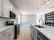 Modern kitchen and bar layout features stainless steel appliances, tile backsplash, and island sink at 145 Ottawa Dr, Louisburg, NC 27549