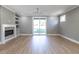 Open living room with electric fireplace, built-in shelves, laminate flooring, and sliding glass doors at 145 Ottawa Dr, Louisburg, NC 27549