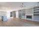 Open concept living room features wood floors, built-in shelves, a fireplace, and an island with sink at 145 Ottawa Dr, Louisburg, NC 27549