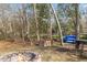 A brick firepit is featured in the backyard amongst the trees and nature at 4708 River Boat Landing Ct, Raleigh, NC 27604