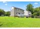 A view of the backyard featuring a deck, green grass, mature trees, and landscaping at 4708 River Boat Landing Ct, Raleigh, NC 27604