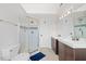Bright bathroom with double vanity, walk-in shower, and neutral tiling at 4708 River Boat Landing Ct, Raleigh, NC 27604